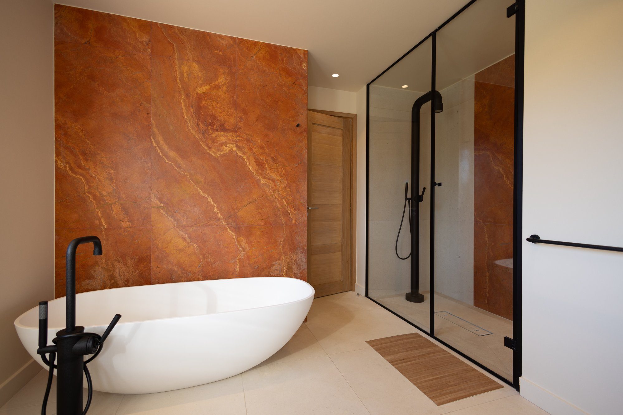 Salle de bains avec baignoire îlot et mur en marbre